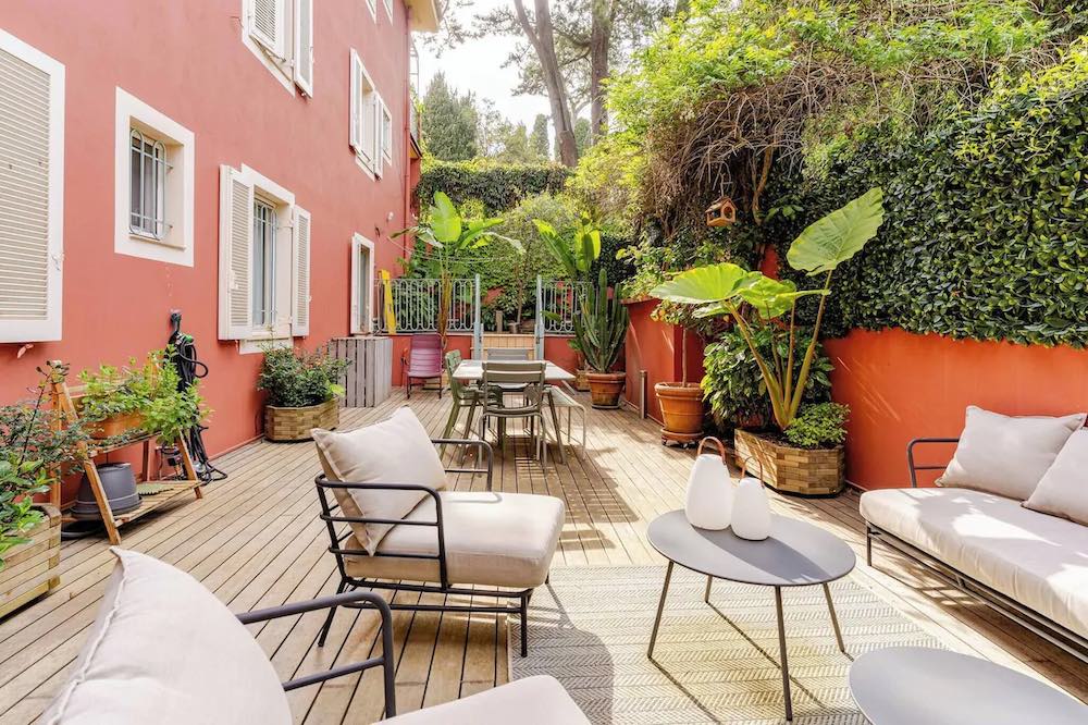 Wooden deck with garden furniture and tropical vegetation