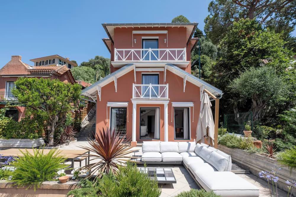 Barn-style house amidst a lush garden with garden furniture
