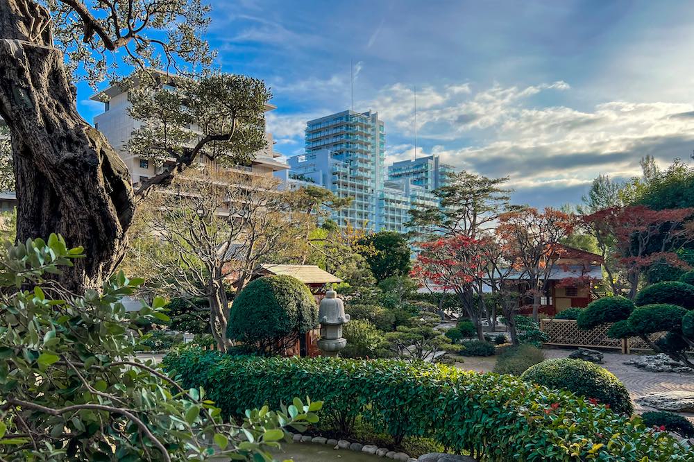 Zen atmosphere of the Japanese Garden of Monaco with the modern Mareterra skyscrapers in the background