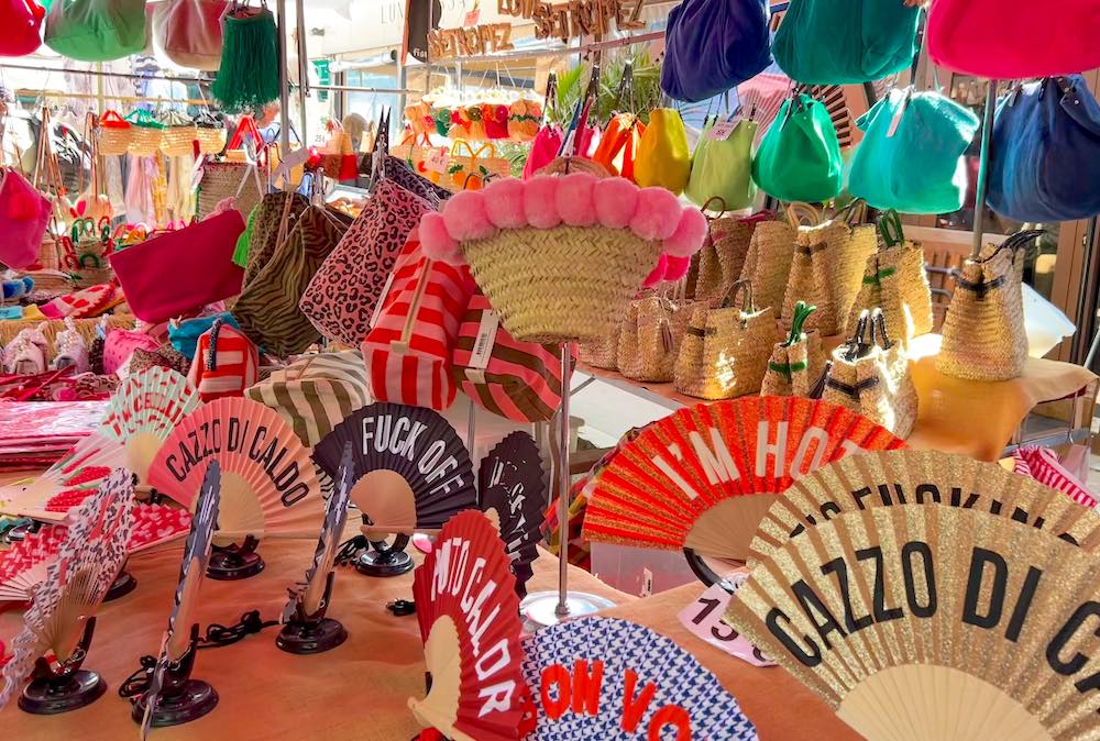 Fans and woven baskets for sale at Place des Lices market in Saint-Tropez