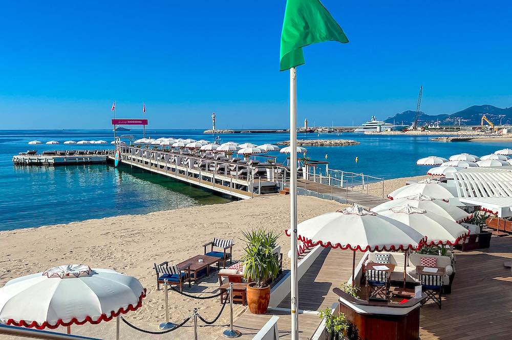Navy and white striped loungers with red cushions at Ciro's Cannes beach club
